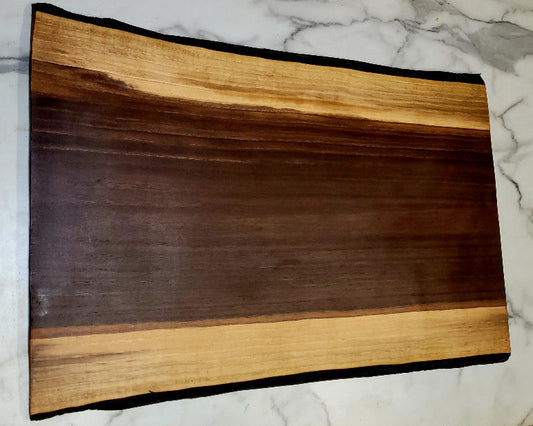A live edge Black Walnut Grazing board.
Medium length, dark centre, with light coloured border, and black bark