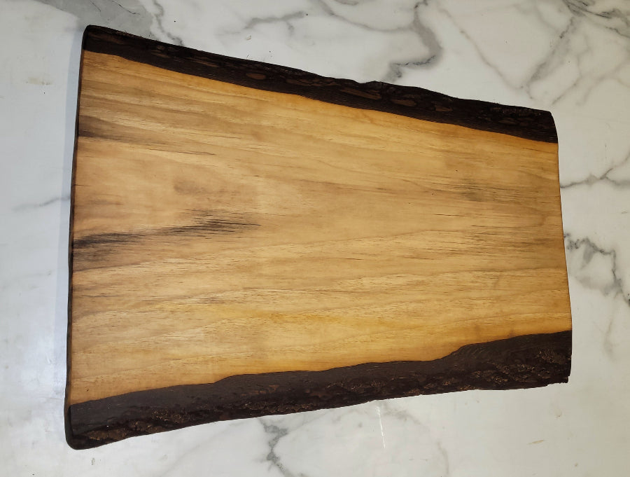 A small grazing board, with light colouring in the middle, and extensive black bark on its edges