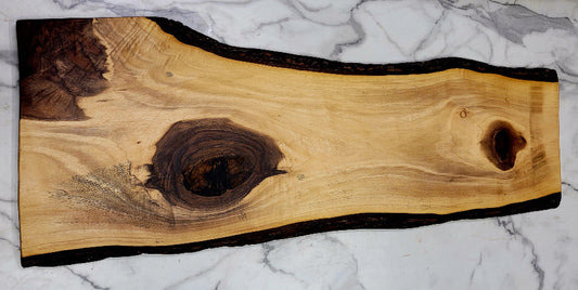 A Large irregularly shaped Live Edge Grazing Board with a light background and three interesting dark colour patches